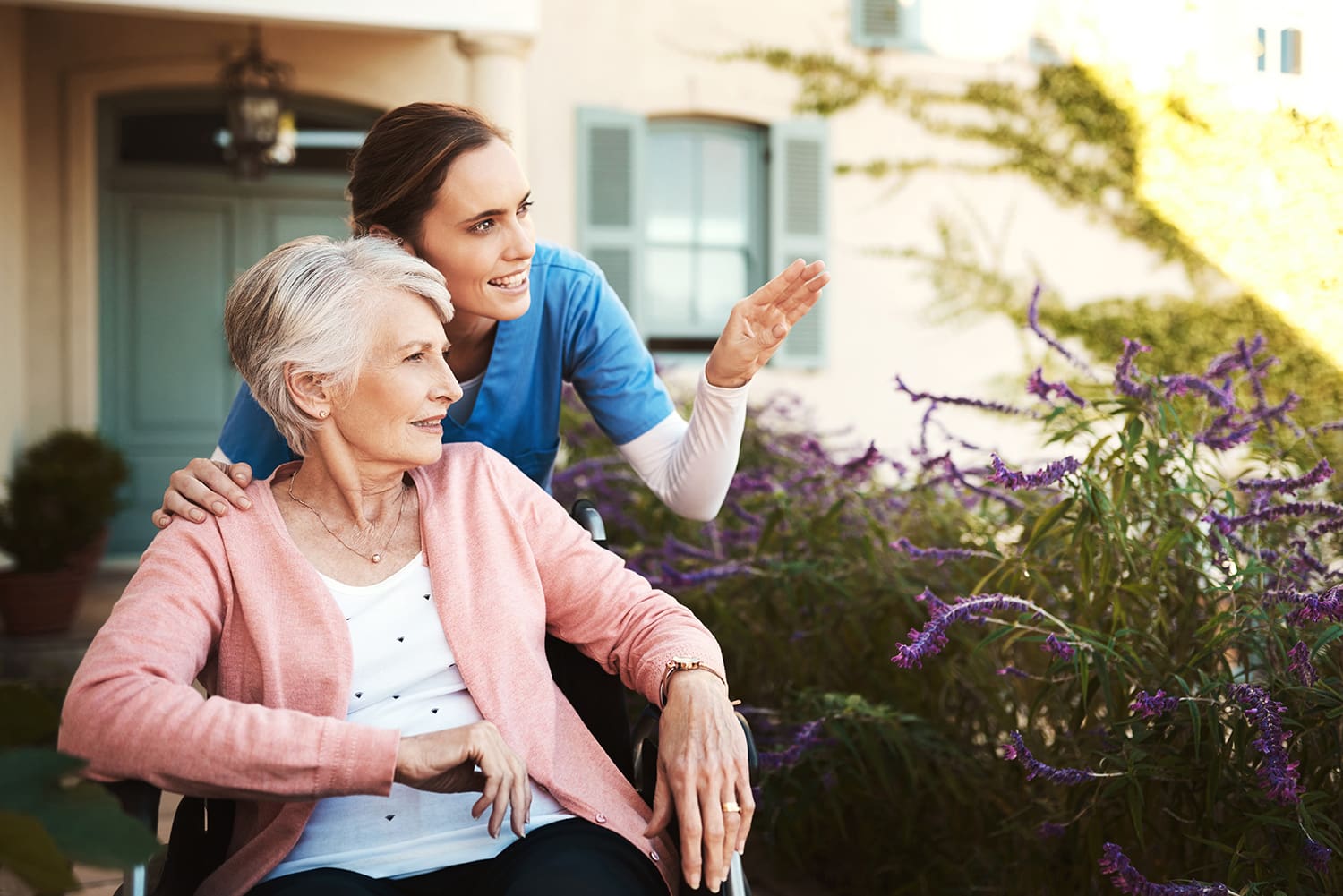 Caregiver and senior resident talking outdoors